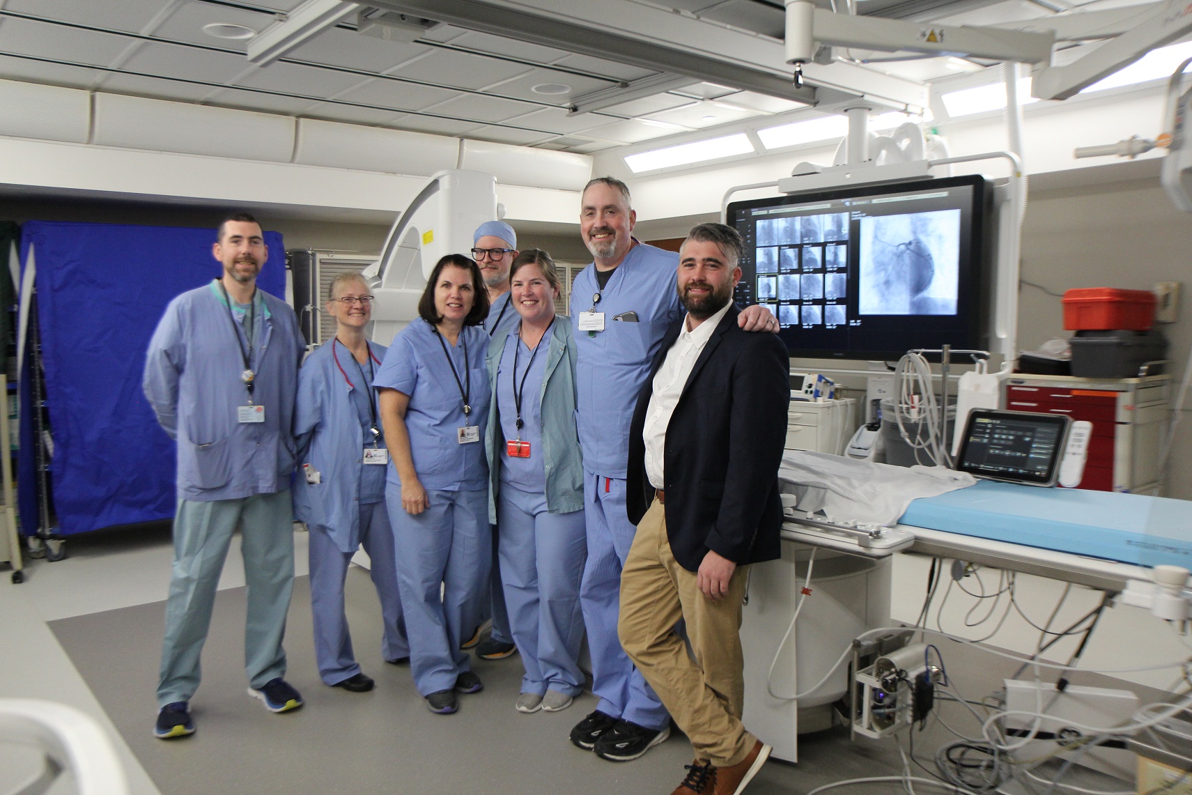 Colleagues from South Shore Health pose for a photo in front of new equipment in the Cath Lab