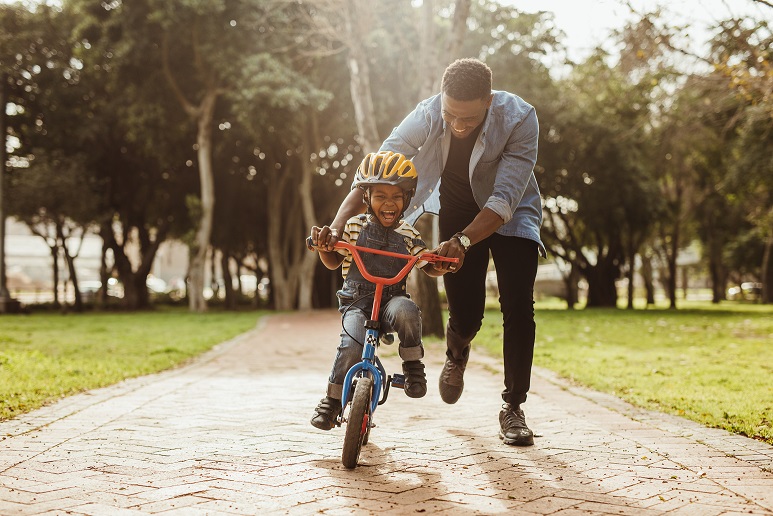 Dad helping son ride a bike