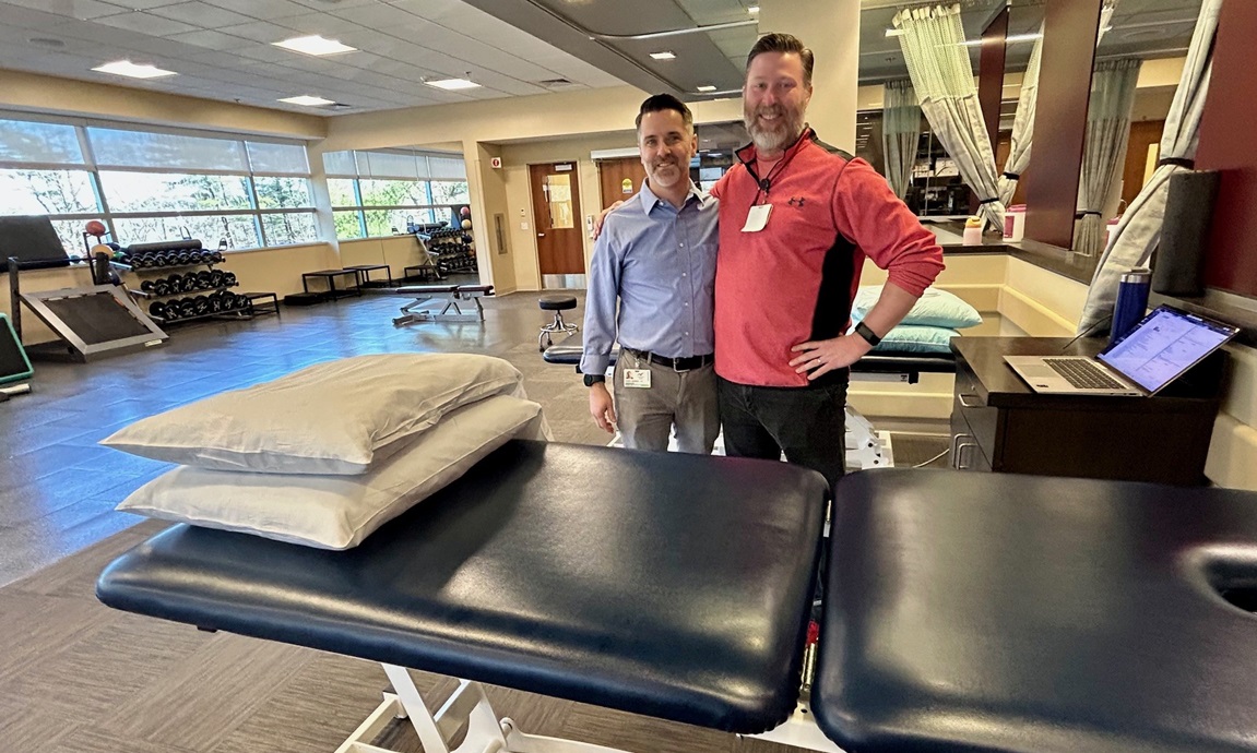Two physical therapists by the treatment beds at Physical Therapy and Wellness