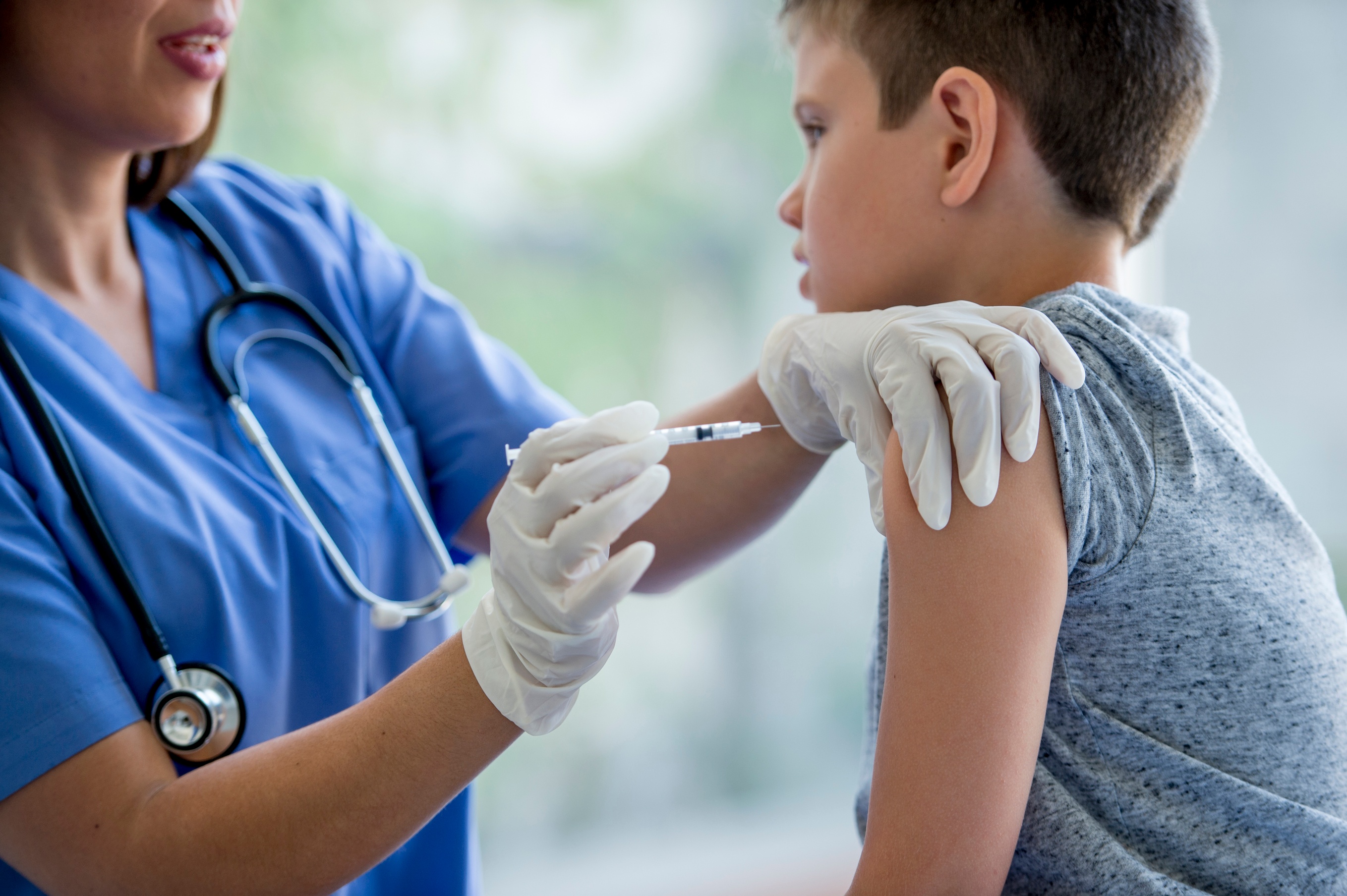 Child being given a flu shot by a nurse