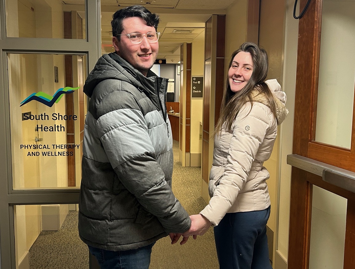 A man and woman holding hands as they walk into an appointment at South Shore Hospital Physical Therapy