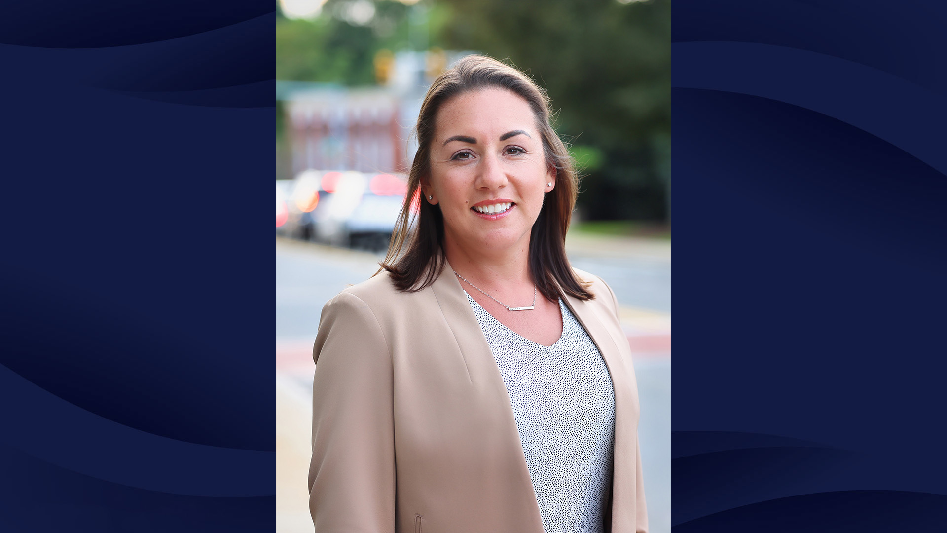 A professional headshot of Sasha Griffith, CRNA on a navy patterned background.