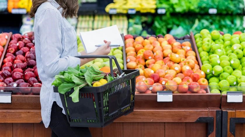 A woman shops for fruits and vegetables at grocery store