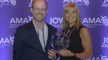 Samuel Ash, MD and Kimberly Dever, MD of South Shore Health pose for a photo with the AMA Joy in Medicine Award trophy.