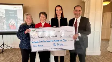 Allen Smith, Lauren Spencer pose with members of The Friends board and an oversized donation check.