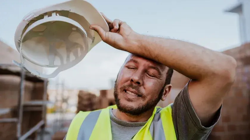 A construction worker wiping his brow amid a heat wave