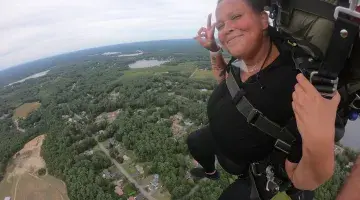A woman doing a skydiving jump with an instructor