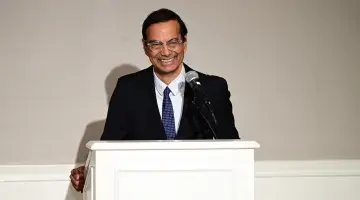 Baba Shetty smiles as he speaks from the podium during a reception in Hingham