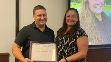 Dr. Fischer and Patty pose with her award certificate.