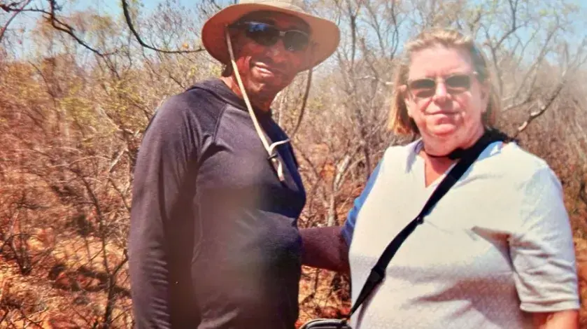 A man and woman pose for a photo in an animal preserve in South Africa