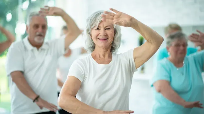 Older women and men practicing tai chi