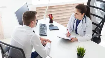 A young male patient consults with female provider at a desk