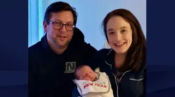 Justin and Renai Townsend hold their New Year's baby, which was born in the backseat of their car.