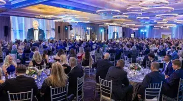 A photo of the ballroom at the 2025 South Shore Health Gala as Jason Tracy, MD speaks on stage.