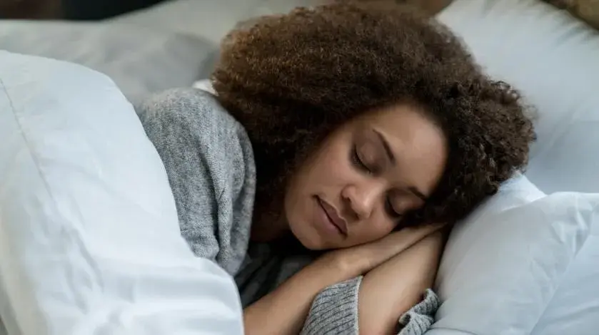 A black woman sleeping peacefully in her bed